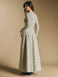 Back view of the cream and black striped long-sleeve maxi dress showing fitted waist and flowing skirt