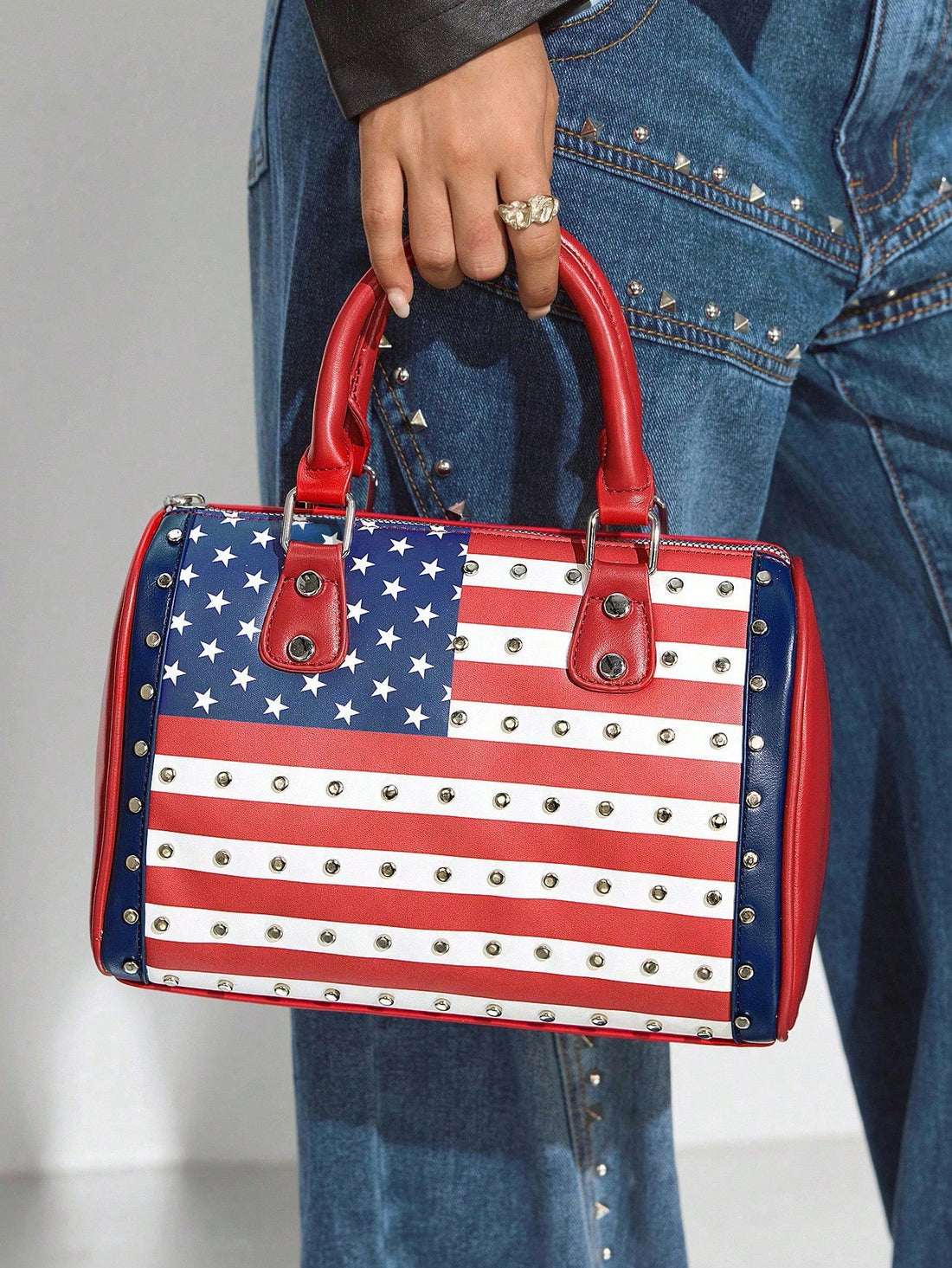 Show off your patriotic spirit with this playful USA Flag Print Top Handle Bag. Perfect for daily errands or weekend getaways, its roomy interior keeps your essentials organized while the sturdy handle ensures easy carrying. Whether you’re headed out for a casual stroll or packing for a trip, this bag adds a fun, stylish flair to any outfit.