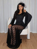 Seated view of black gothic formal maxi dress with wide flared sleeves and lace detail