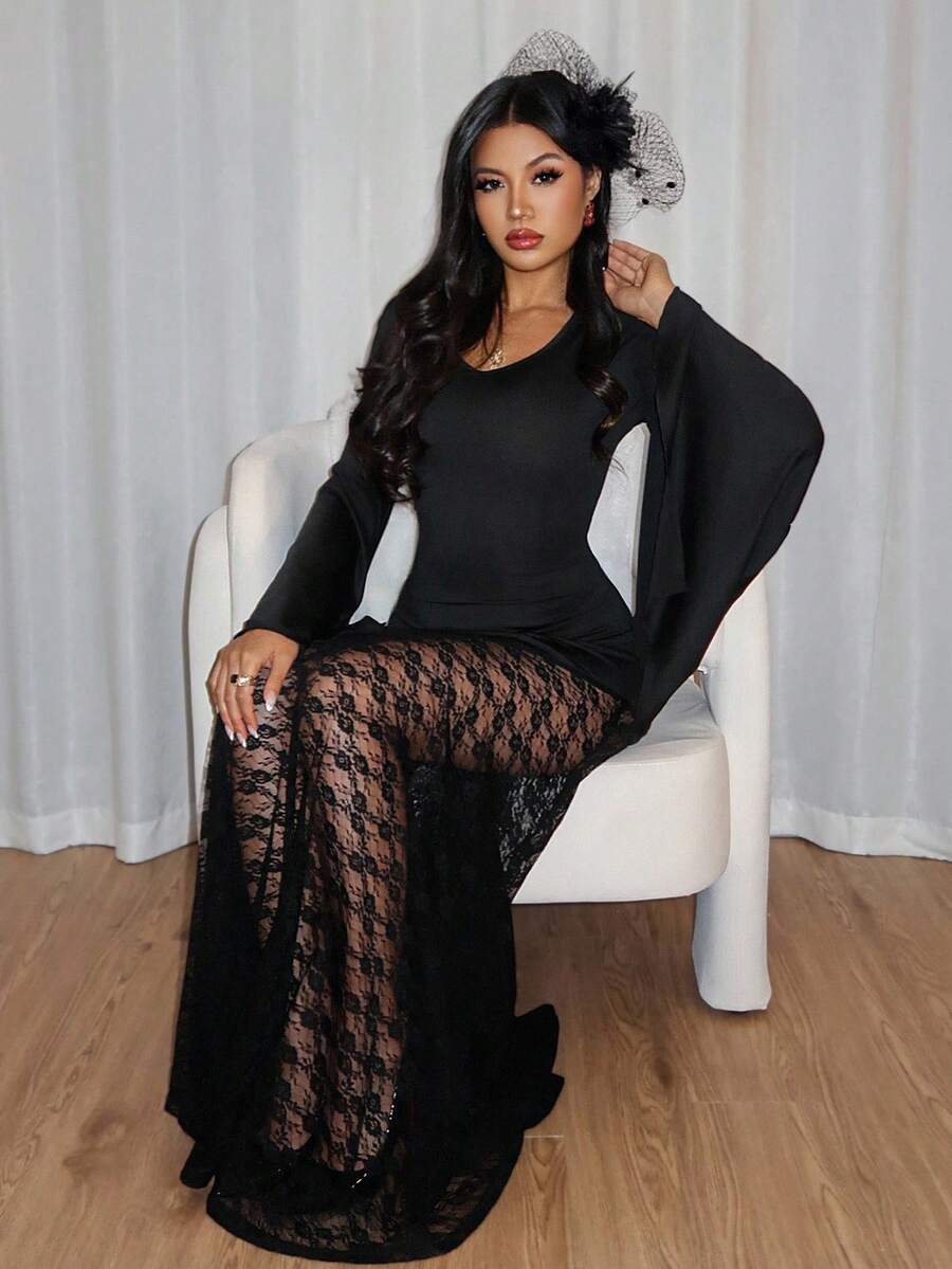 Seated view of black gothic formal maxi dress with wide flared sleeves and lace detail
