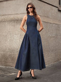 Full front street-style view of dark-indigo sleeveless denim maxi dress with wide A-line skirt