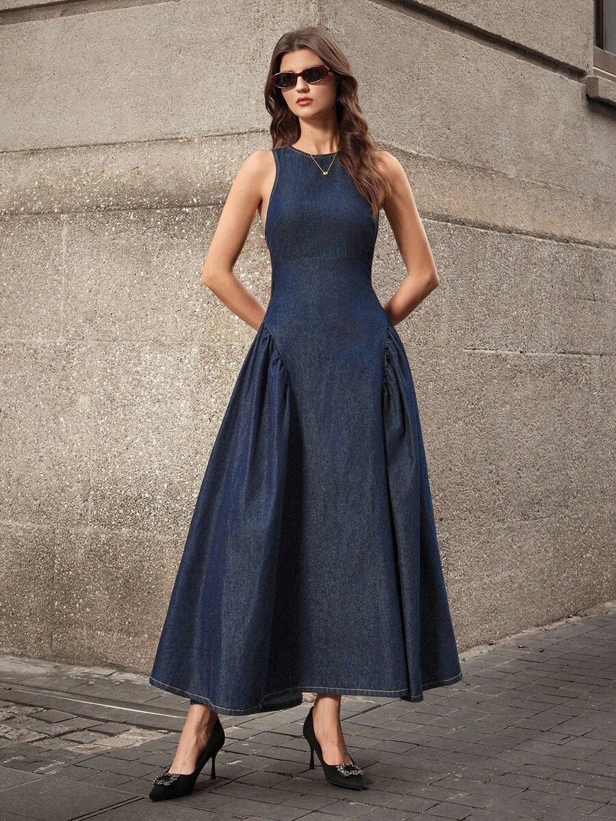 Full front street-style view of dark-indigo sleeveless denim maxi dress with wide A-line skirt