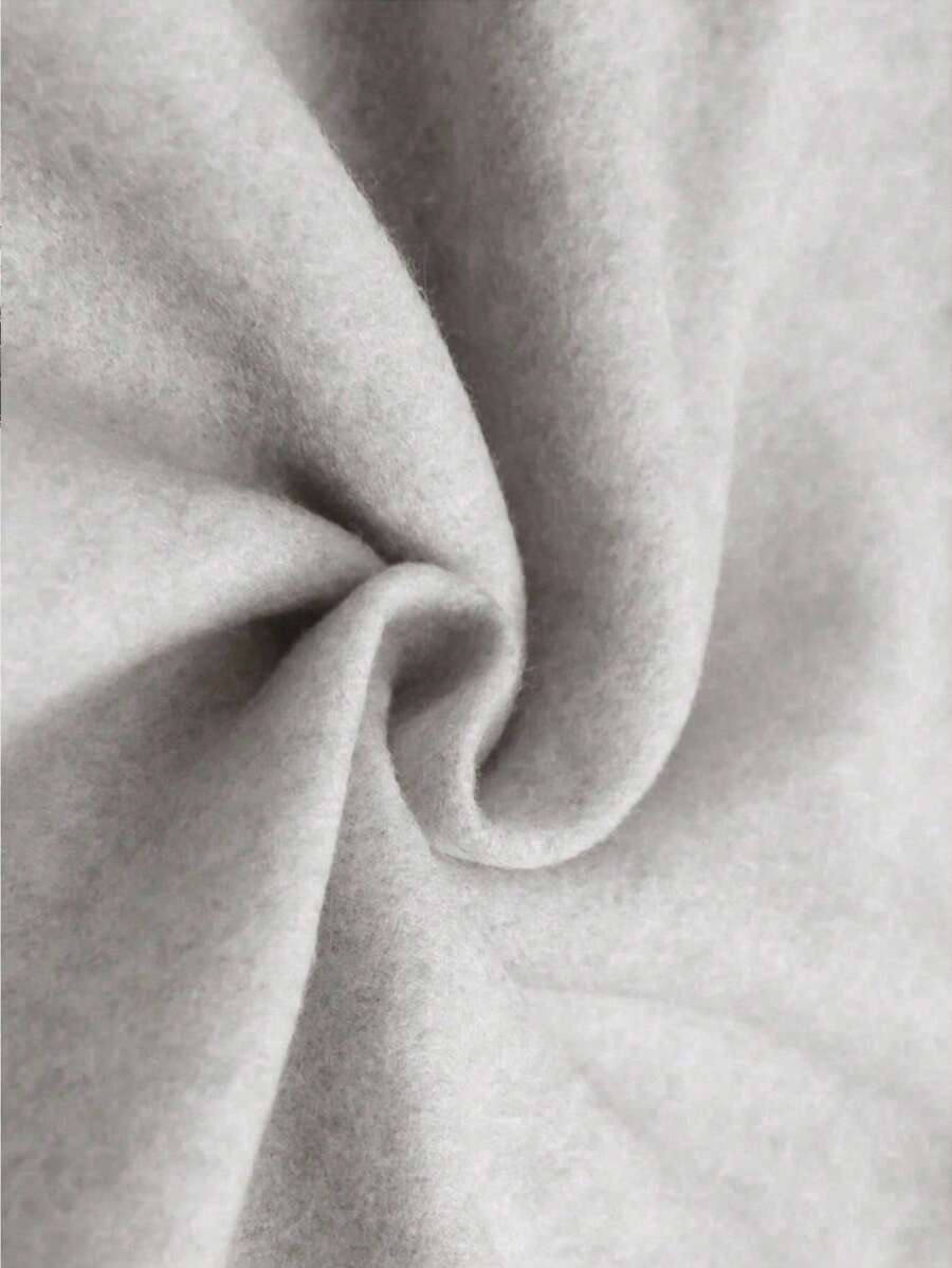 Close-up of light heather-gray sweatshirt fabric showing soft heathered surface and folds