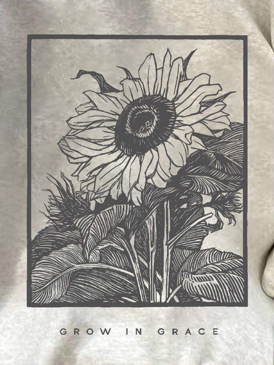 Close-up of dark charcoal sunflower and Grow in Grace print on gray sweatshirt front