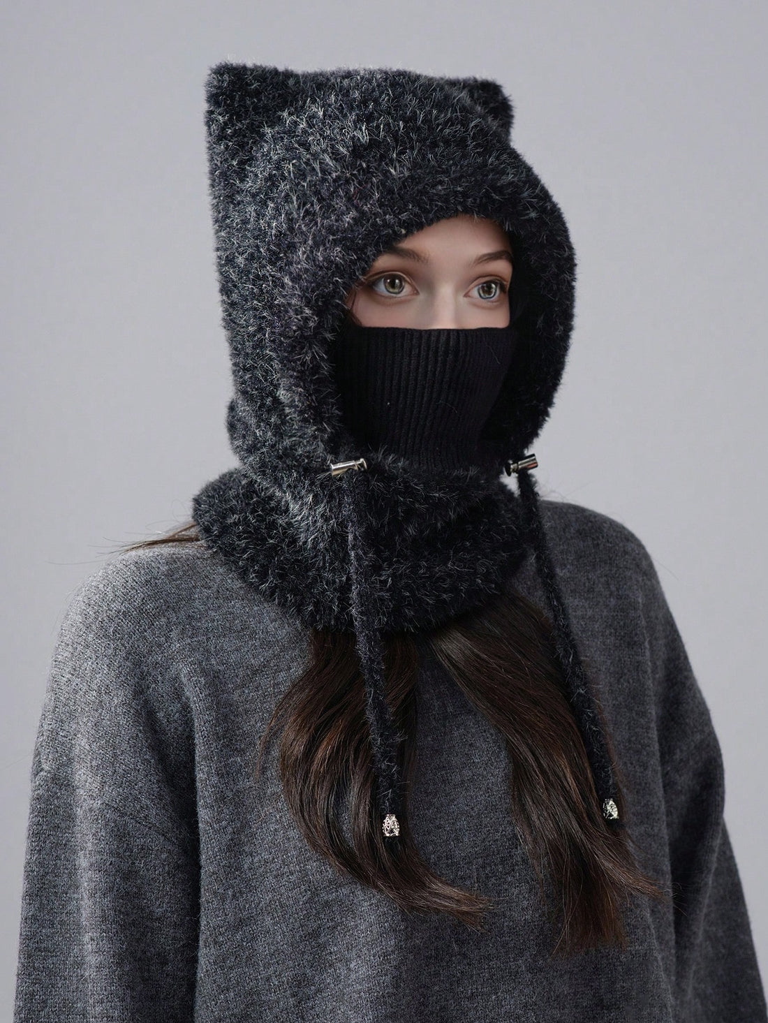 Front portrait of model wearing taupe plush hooded balaclava with ribbed face cover and hanging cords