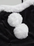 Close-up of white faux fur neckline trim and pom-pom accents on black dress