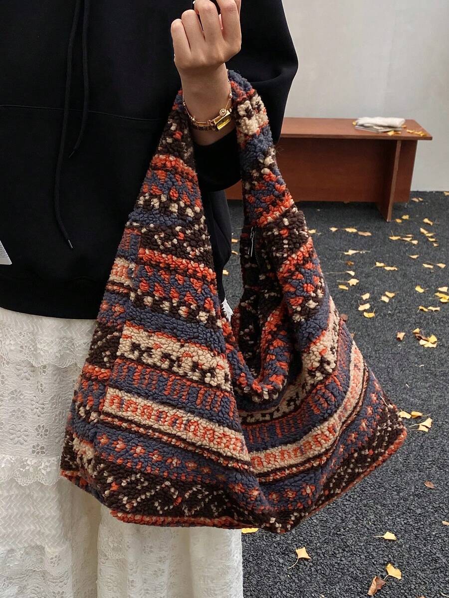 Model wearing oversized fuzzy hobo tote with navy rust cream geometric stripes
