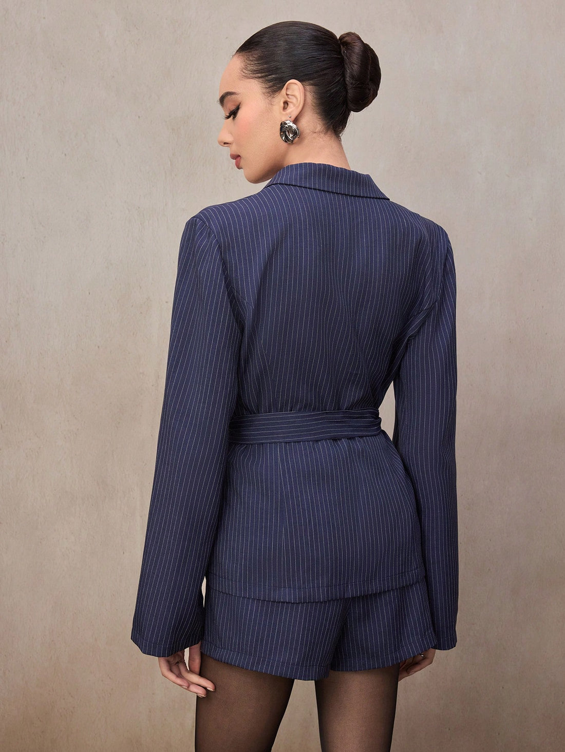 Elevate your wardrobe with this fabulous navy blue striped suit set that's equal parts sophisticated and fun! The loose-fit blazer drapes beautifully for all-day comfort, while the A-line shorts add a modern twist to classic tailoring. Mix and match these pieces with your favorite tops and accessories, or wear them together for an instant polished look. Perfect for brunch dates, office days, or whenever you want to feel effortlessly chic. This two-piece ensemble proves that style doesn't have to sacrifice c