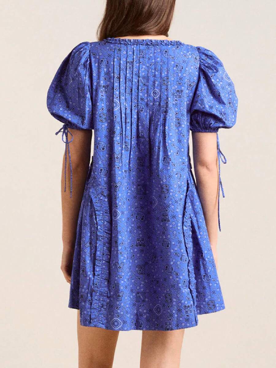 Front view of cobalt blue paisley smock mini dress with ruffled neck and puff sleeves