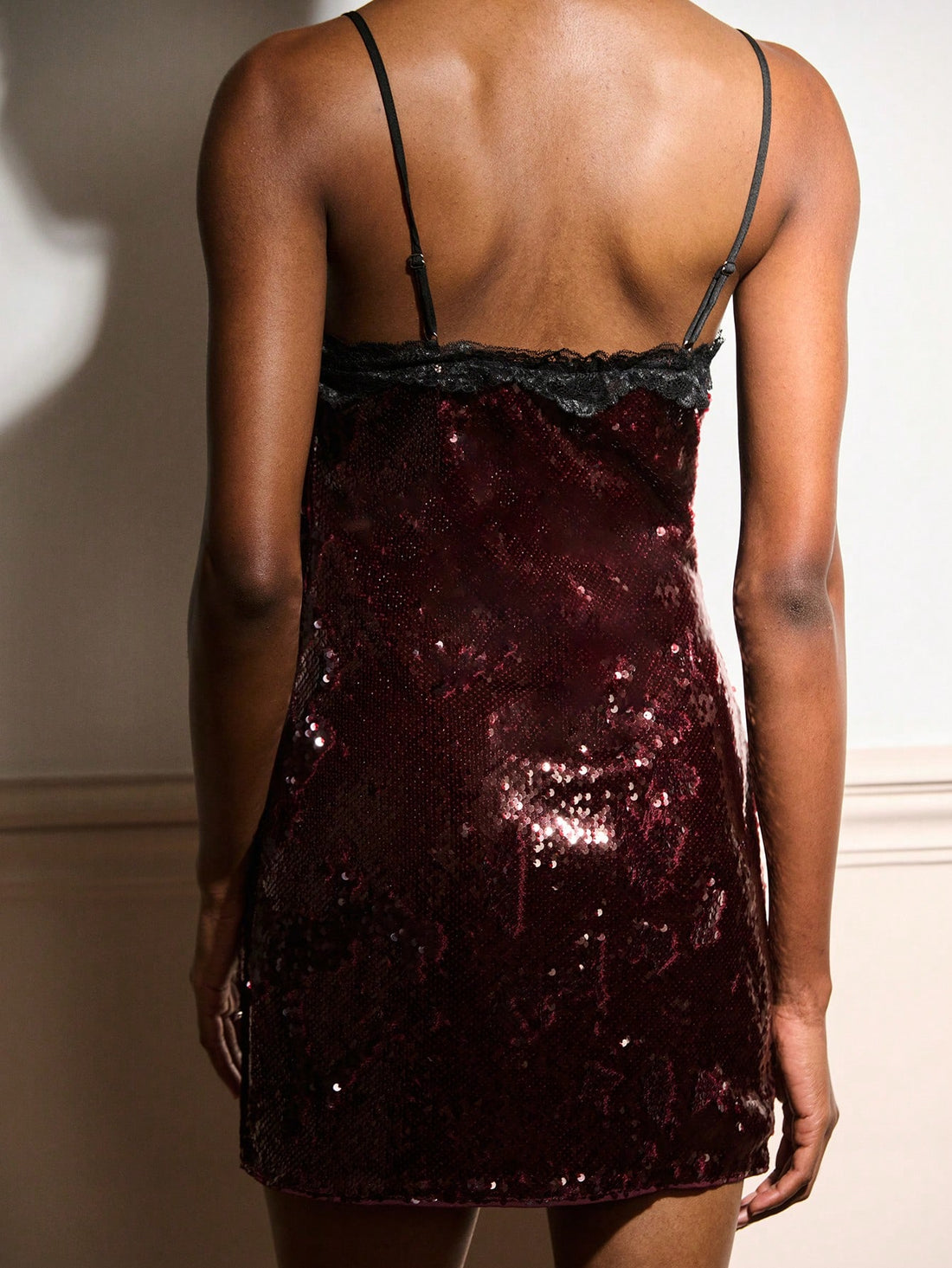 Shimmer into the spotlight with this stunning burgundy sequin mini dress that's pure magic for evening affairs. The luxe sequin fabric catches every light, creating an irresistible sparkle, while delicate black lace trim adds sophisticated contrast and refined edge. Perfect for cocktail parties, date nights, or any occasion calling for glamorous flair, this dress transforms you into the most dazzling guest in the room. The flattering mini silhouette keeps things fun and flirty, making it your go-to piece fo