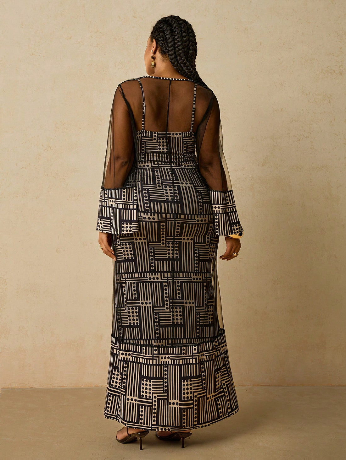 Make a statement in this stunning plus-size camisole dress featuring bold African geometric patterns that celebrate cultural artistry. The sleek cami silhouette pairs beautifully with the included mesh shawl, offering versatile styling for any occasion. Whether you're heading to a party, special event, or night out, this elegant ensemble delivers confidence and flair. The flowing design flatters your figure while the intricate patterns add visual interest and personality. Dress it up with heels and jewelry,