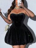 Side view of black strapless peplum party dress with sheer mesh arm sleeves
