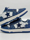 Blue and white low-top denim sneakers stacked with navy laces, star patches, cream midsole, and blue outsole