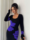 Close front view of black and blue-violet floral sweater dress with ribbed square neckline and cuffs
