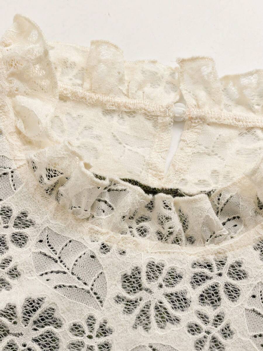 Close-up of ivory floral lace ruffled neckline and concealed zipper on plaid dress