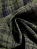 Close-up of olive green and navy tartan woven fabric on plaid A-line dress