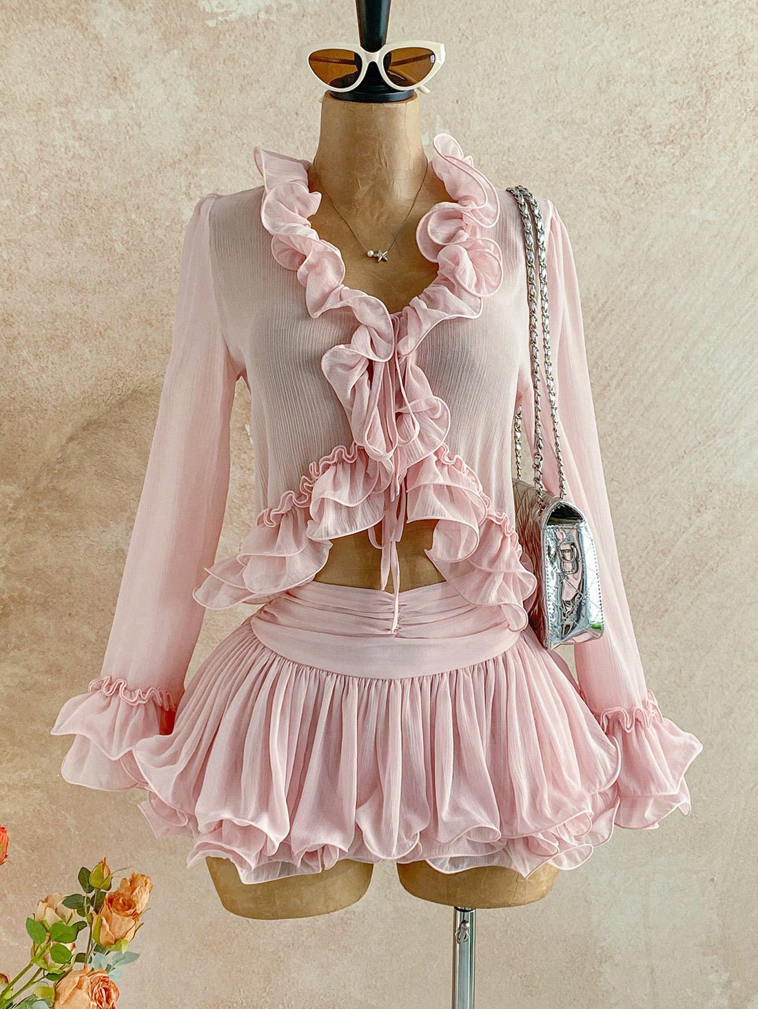 Embrace your inner free spirit with this enchanting two-piece set! The delicate ruffle tie-front cardigan layers beautifully over the blush pink mini skirt, creating an effortlessly chic silhouette that's perfect for brunch dates or weekend adventures. Mix bohemian elegance with modern flair—this pairing brings that coveted boho-chic vibe without trying too hard. Whether you're dressing it up with heels or keeping it casual with sneakers, this set is your new go-to for looking put-together and playfully sty