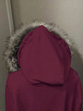 Close view of wine red jacket hood with soft grey faux-fur trim