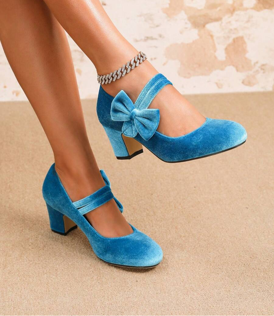 Step into sophistication with these charming Mary Jane heels that blend timeless elegance with modern flair. Crafted from luxurious velvet, they feature a delicate bow accent and rounded toe for all-day comfort. Whether you're dancing at a wedding, hosting a party, or elevating your everyday look, these versatile heels deliver instant polish. The classic Mary Jane strap keeps your foot secure while the refined silhouette flatters any outfit. A must-have for anyone who loves shoes that work as hard as they d