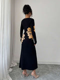 Back full view of black and peach floral slim-fit knit midi dress with subtly flared hem