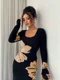 Close front view of black and peach floral sweater dress with ribbed square neckline and cuffs