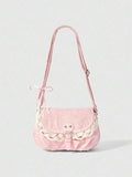 Pink corduroy shoulder bag with faint white print lace trim and buckle strap