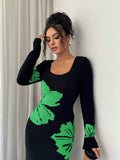 Close front view of black and green floral sweater dress with ribbed square neckline and cuffs