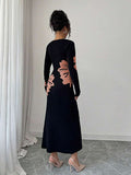 Back full view of black and peach floral slim-fit knit midi dress with subtly flared hem