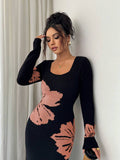 Close front view of black and peach floral sweater dress with ribbed square neckline and cuffs