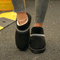Overhead view of black slip-on boots showing white cotton lining