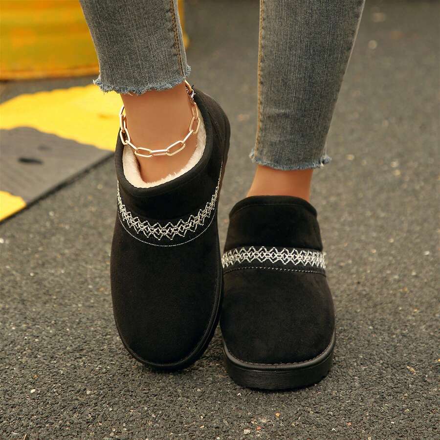Overhead view of black slip-on boots showing white cotton lining