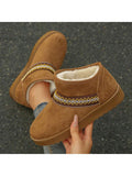 Handheld front view of camel fuzzy ankle boot with embroidered band