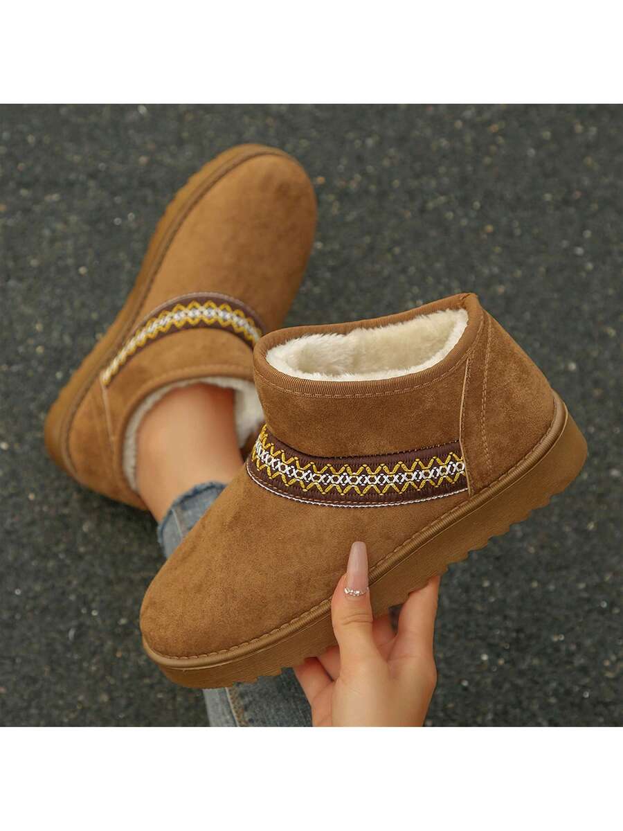 Handheld front view of camel fuzzy ankle boot with embroidered band