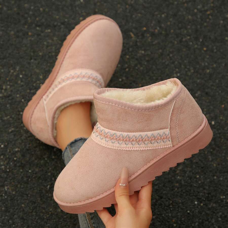 Handheld top view of pink suedette boot showing white fuzzy lining