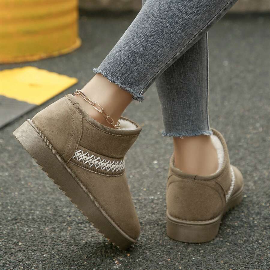 Rear three-quarter view of khaki ankle boots showing heel seams