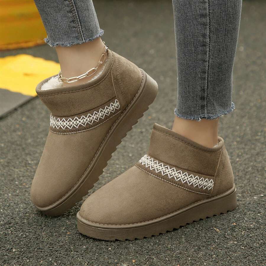 Front three-quarter view of khaki fuzzy boots with treaded TPR soles