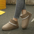 Outdoor side view of khaki slip-on ankle boots worn with jeans