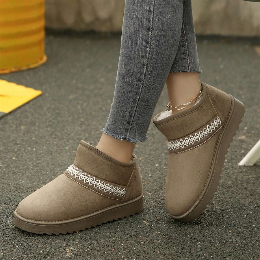 Outdoor side view of khaki slip-on ankle boots worn with jeans