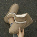 Handheld front view of khaki fuzzy ankle boot with white embroidery