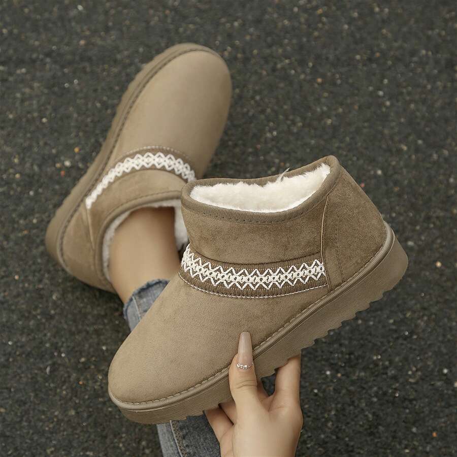 Handheld front view of khaki fuzzy ankle boot with white embroidery
