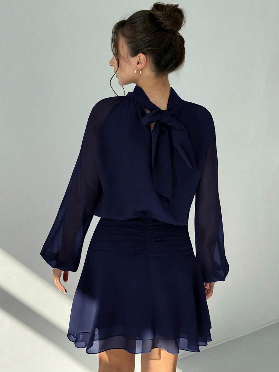 Slip into effortless sophistication with this chic mini dress that's equal parts polished and fun. The fitted waist creates a flattering silhouette while long sleeves add an unexpected touch of elegance to the playful hemline. Available in timeless solid colors, it's your go-to piece for everything from casual brunches to evening outings. Dress it up with heels or keep it relaxed with sneakers—this versatile number adapts to your vibe.