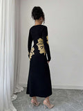 Back full view of black and beige floral slim-fit knit midi dress with subtly flared hem