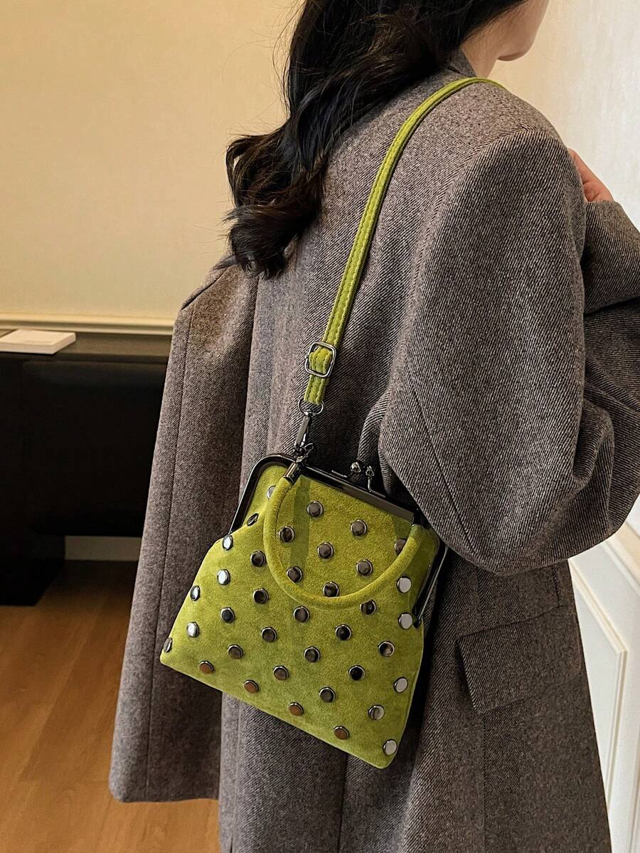 Olive green studded kiss-lock handbag worn with gray blazer
