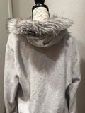Back view of light grey graphic hooded zip-up jacket with faux-fur trimmed hood