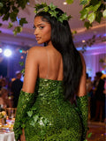Rear three quarter view of green sequin strapless ivy gown with leaf crown and opera gloves