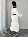 Back view of white and black rib-knit A-line midi dress with high waist and long bishop sleeves