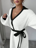 Close view of white and black button-front sweater midi dress with V-shaped polo collar and tied knit belt