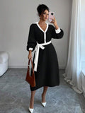 Close view of cream and black button-front sweater midi dress with V-shaped polo collar and tied knit belt