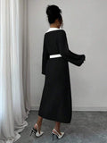 Front view of black and white belted polo collar knit midi dress with bishop sleeves and button front