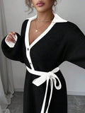 Back view of black and white rib-knit A-line midi dress with high waist and long bishop sleeves